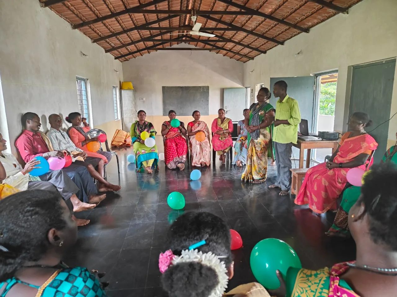 Siddi community members participating in interactive group activities with balloons during the development workshop